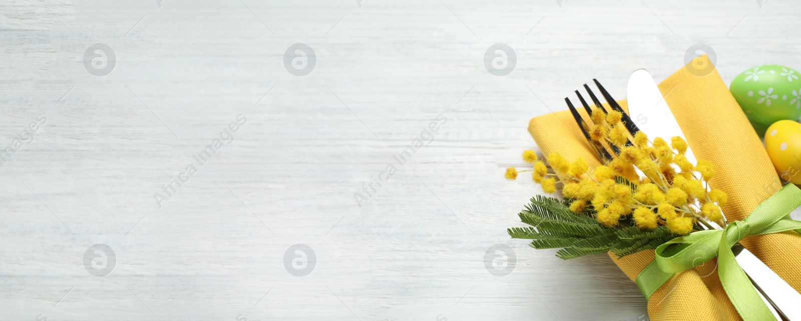 Image of Closeup view of cutlery set with floral decor on wooden table, space for text. Easter celebration