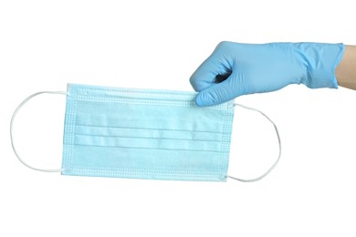 Doctor in latex gloves holding medical mask on white background, closeup