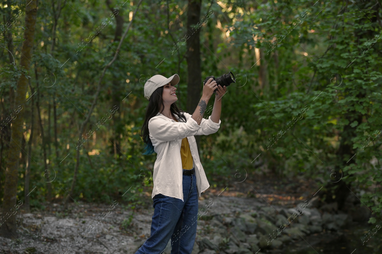 Photo of Beautiful woman with camera spending time in nature reserve