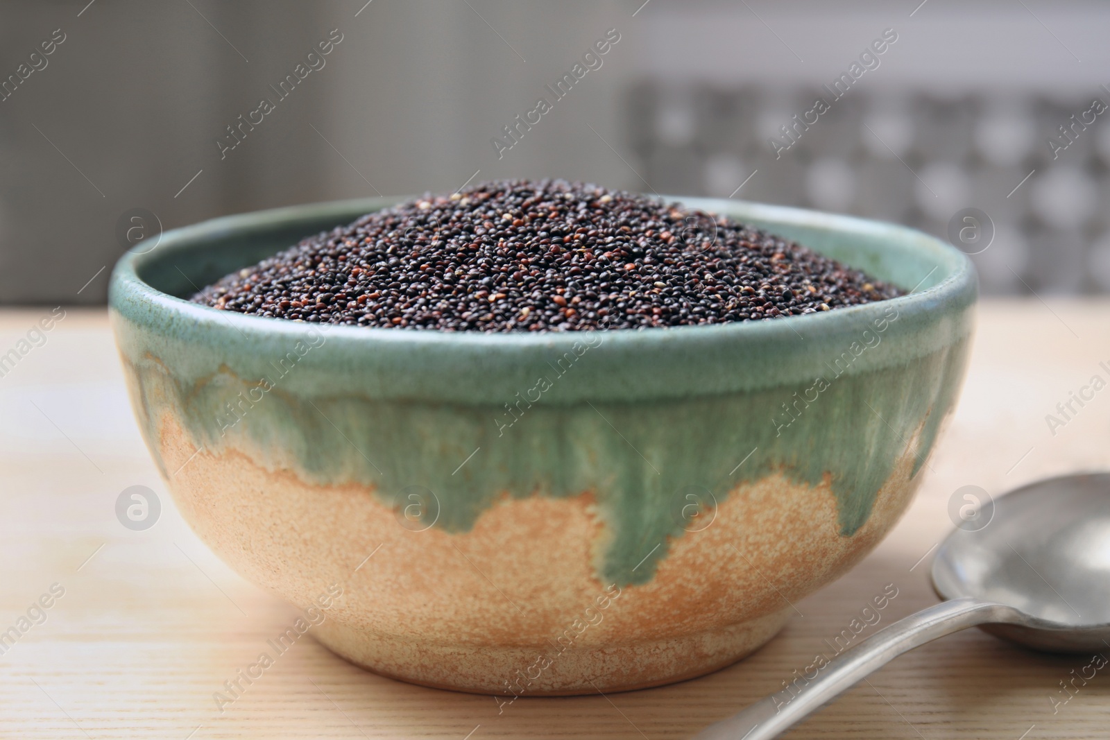 Photo of Bowl with black quinoa on wooden table