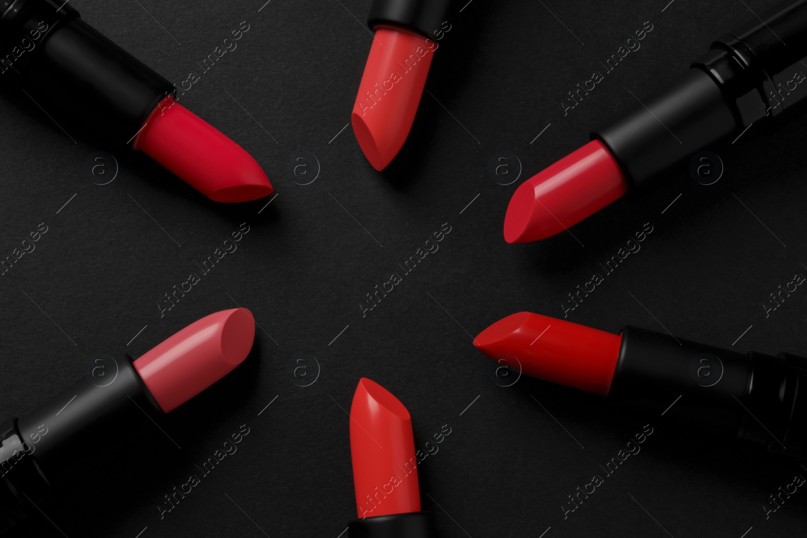 Photo of Beautiful lipsticks on black background, flat lay