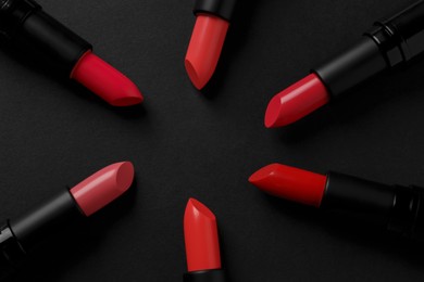 Beautiful lipsticks on black background, flat lay