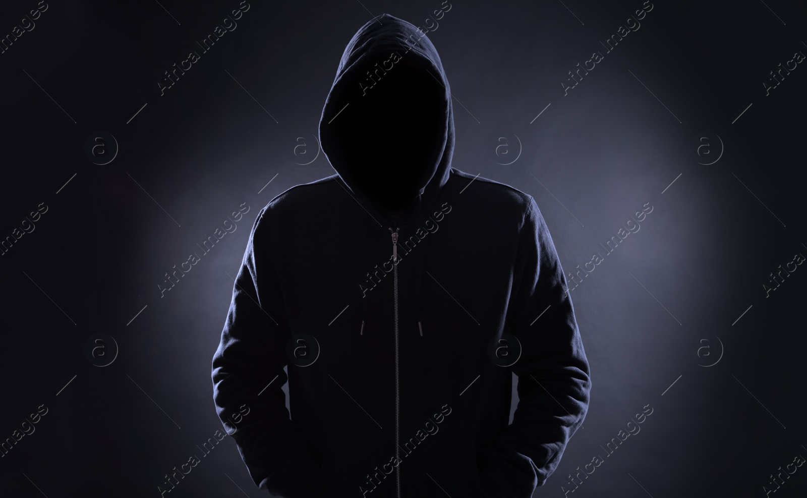 Image of Anonymous man in hood on black background