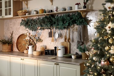 Stylish kitchen with festive decor and Christmas tree. Interior design