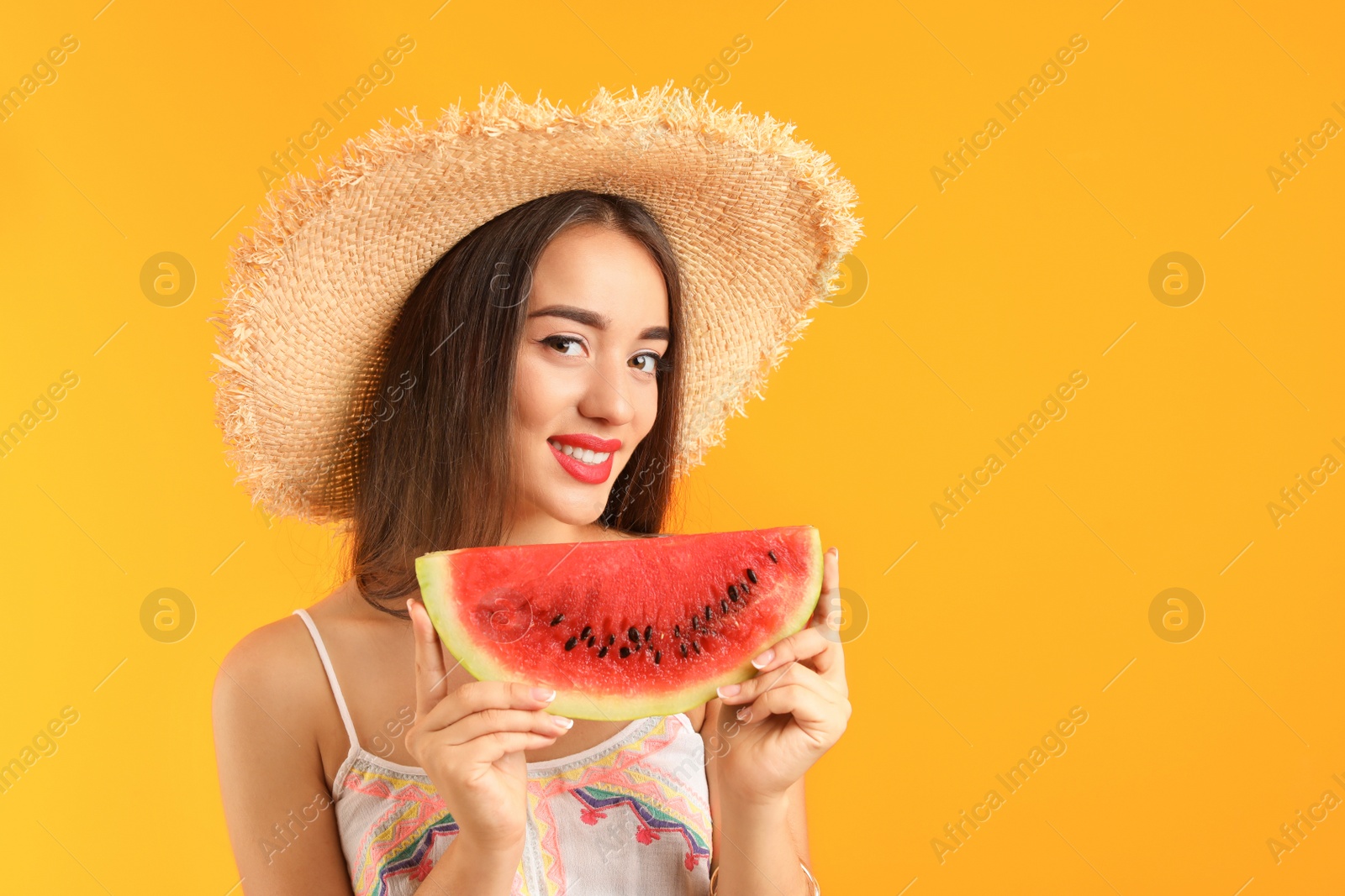 Photo of Beautiful young woman posing with watermelon on color background