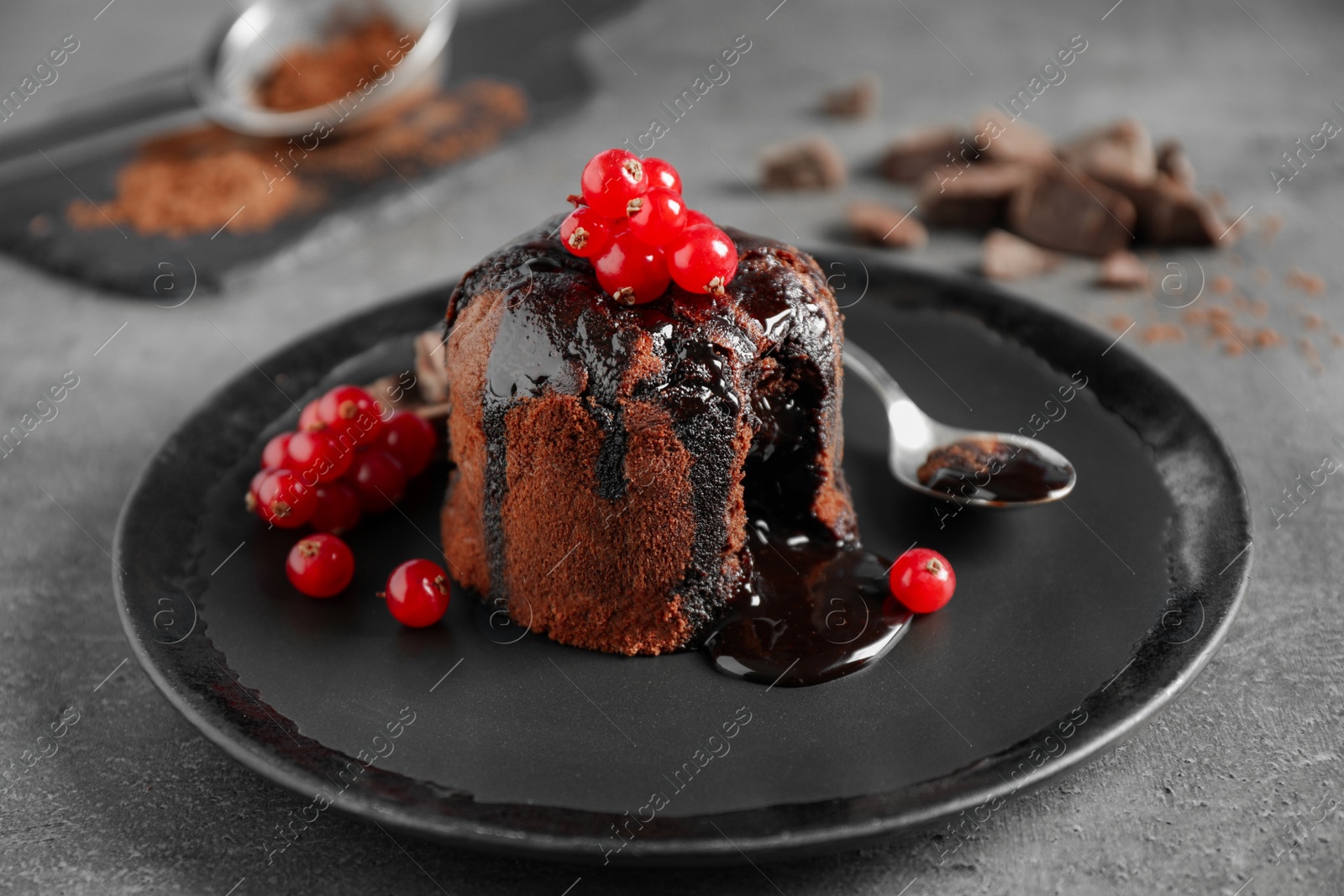 Photo of Delicious warm chocolate lava cake with berries on grey table