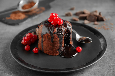 Delicious warm chocolate lava cake with berries on grey table