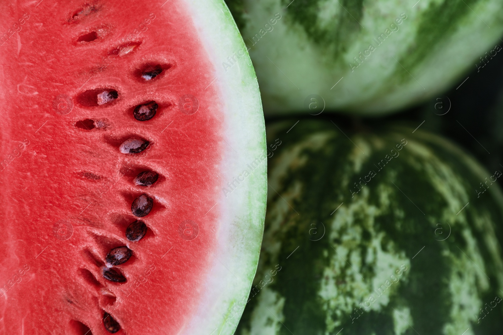Photo of Delicious whole and cut watermelons as background, closeup