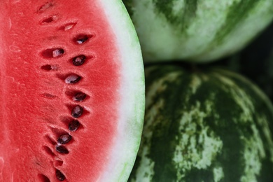 Photo of Delicious whole and cut watermelons as background, closeup