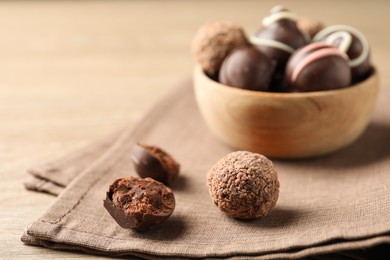 Different delicious chocolate truffles on wooden table