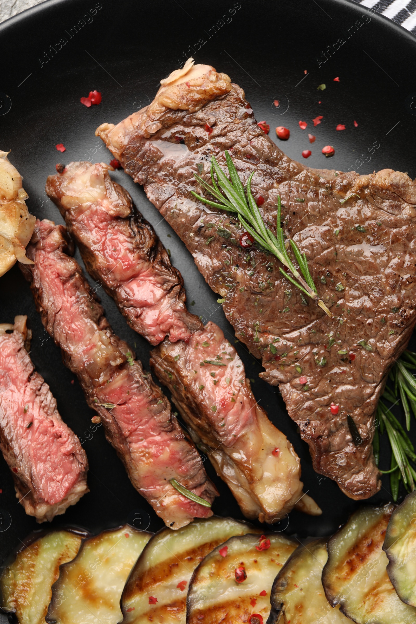 Photo of Delicious grilled beef steak with vegetables and spices on plate, top view