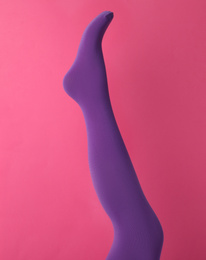 Leg mannequin in purple tights on pink background
