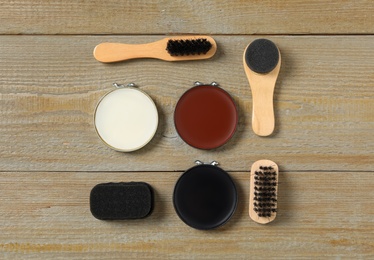 Flat lay composition with shoe care accessories on wooden background