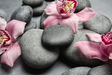 Zen stones and exotic flowers on dark background, closeup