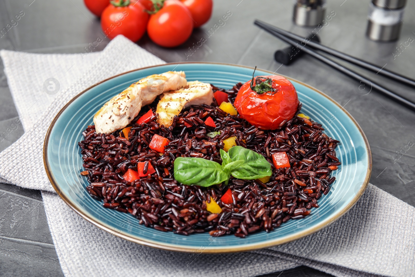 Photo of Plate with delicious cooked brown rice on grey table