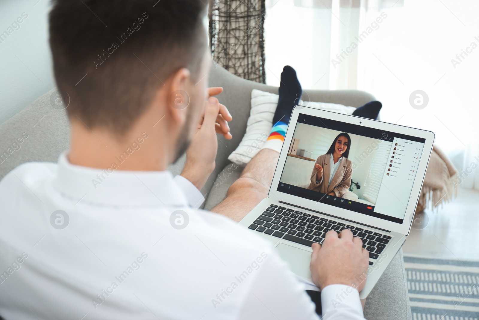 Photo of Businessman wearing shirt and underwear during video call at home, back view