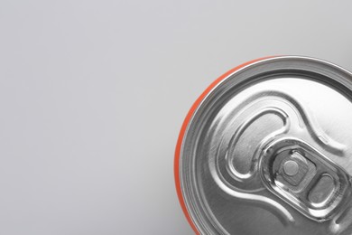 Photo of Energy drink in can on grey background, top view. Space for text