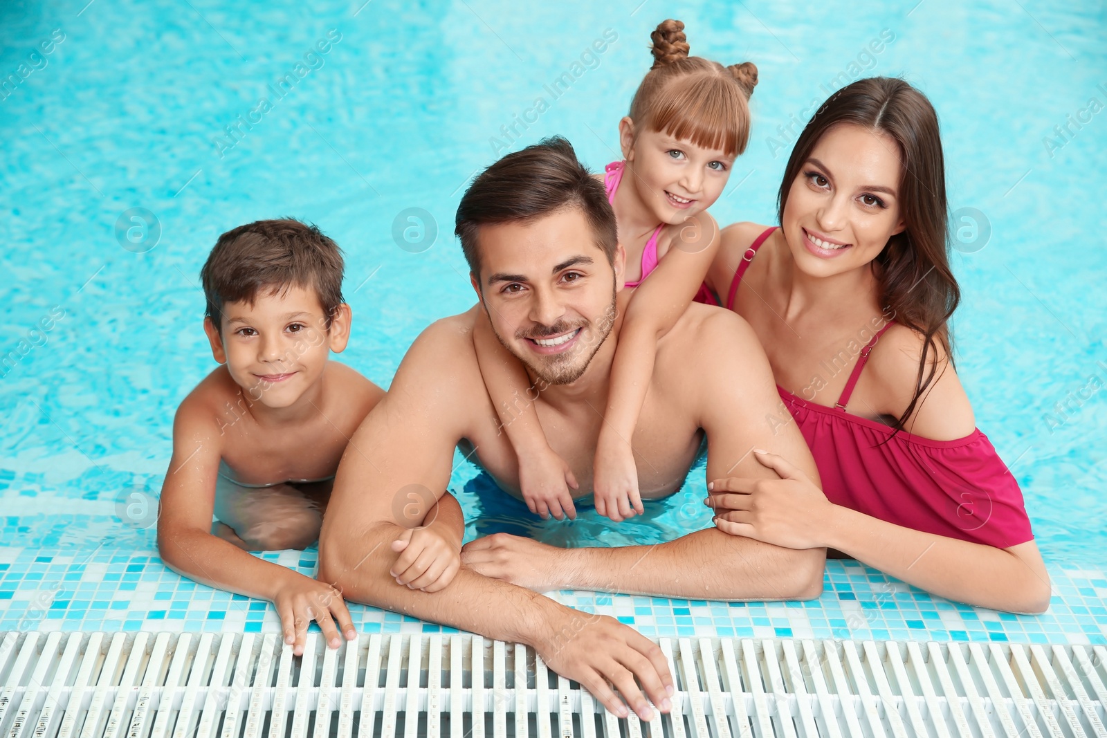 Photo of Happy family resting in swimming pool with refreshing water