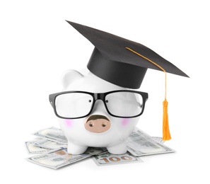 Photo of Money bills and piggy bank with glasses in graduation hat isolated on white
