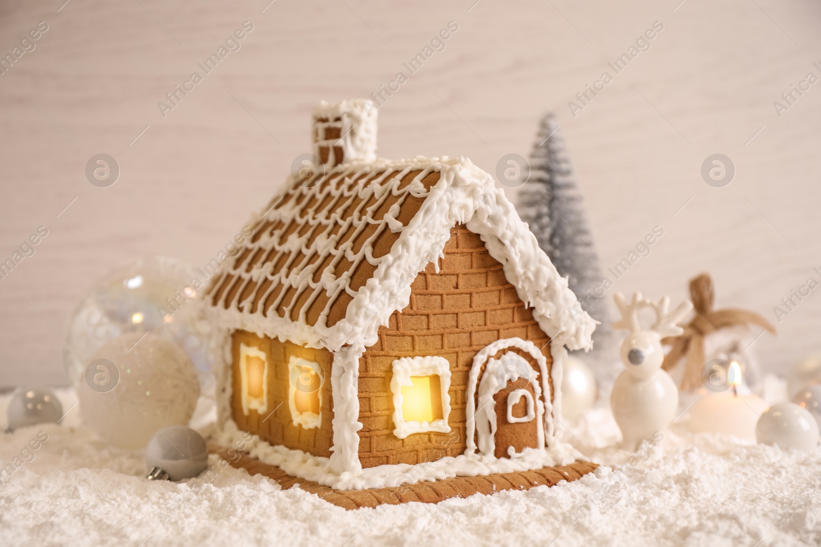 Photo of Beautiful gingerbread house decorated with icing on snow