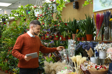 Male business owner with tablet in his flower shop