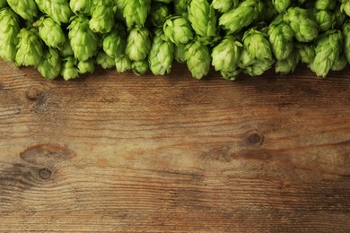 Photo of Fresh green hops on wooden table, top view. Space for text