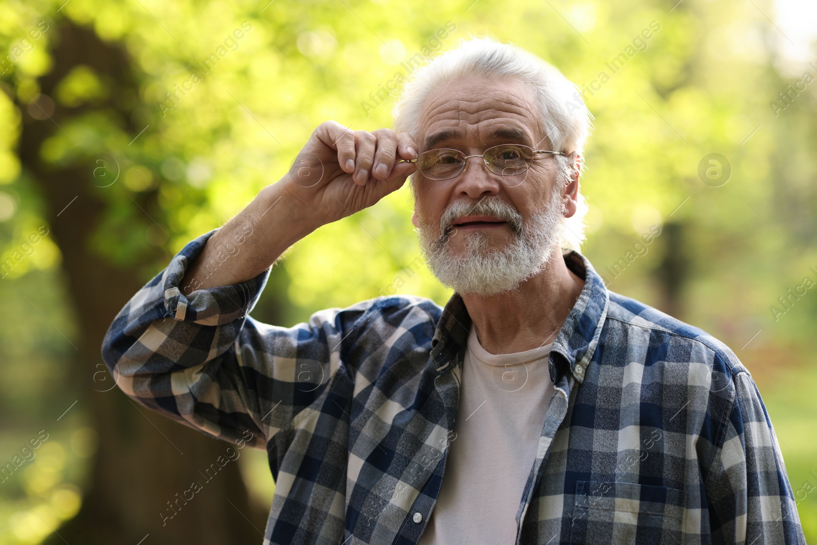 Photo of Portrait of happy grandpa with glasses in park