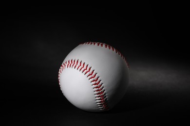 Photo of One leather baseball ball on black background