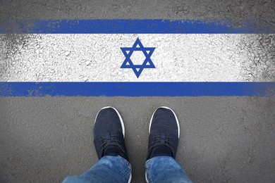 Image of Immigration. Man standing on asphalt near flag of Israel, top view