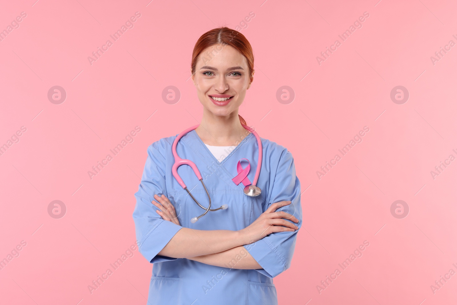 Photo of Mammologist with pink ribbon on color background. Breast cancer awareness