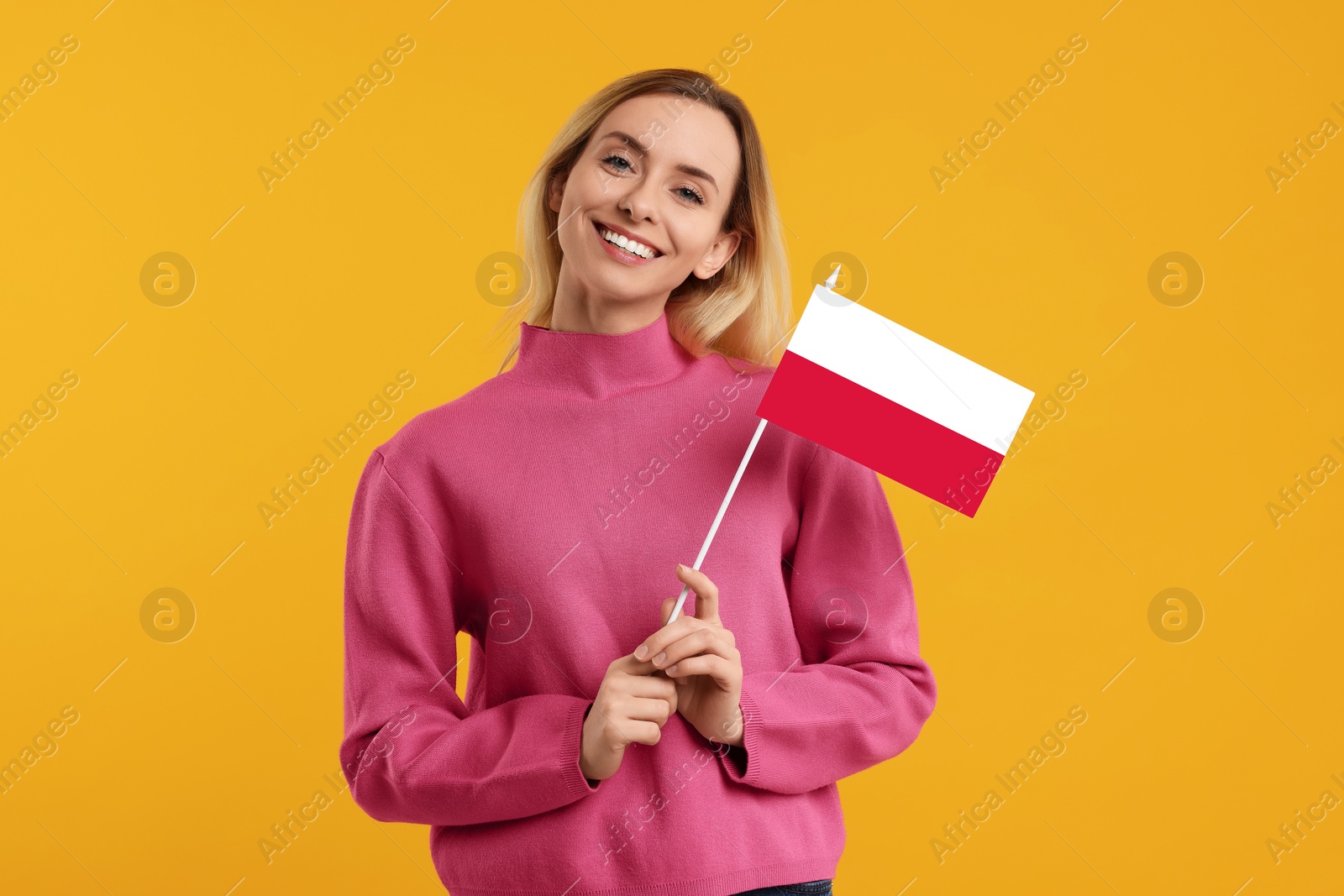 Image of Happy young woman with flag of Poland on yellow background
