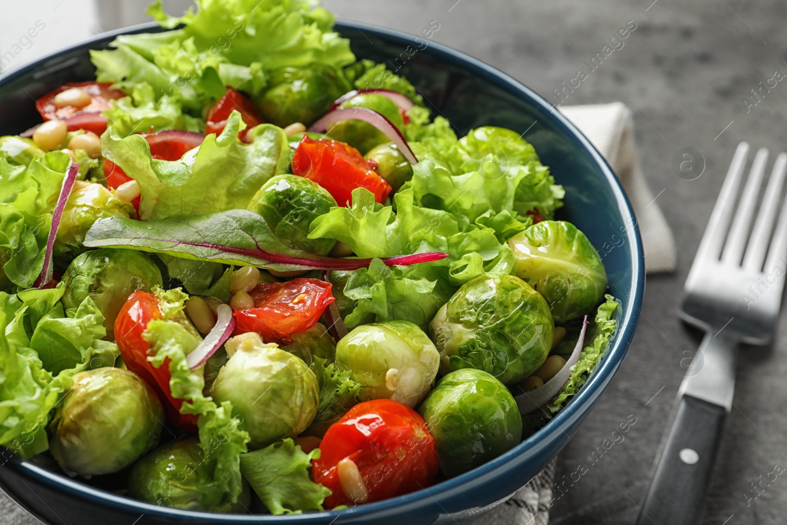 Photo of Bowl of salad with Brussels sprouts on table, closeup