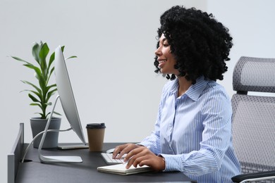 Young woman working on computer at table in office