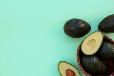 Photo of Tasty fresh avocados on turquoise background, flat lay. Space for text