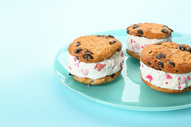 Photo of Sweet delicious ice cream cookie sandwiches on light blue background, closeup