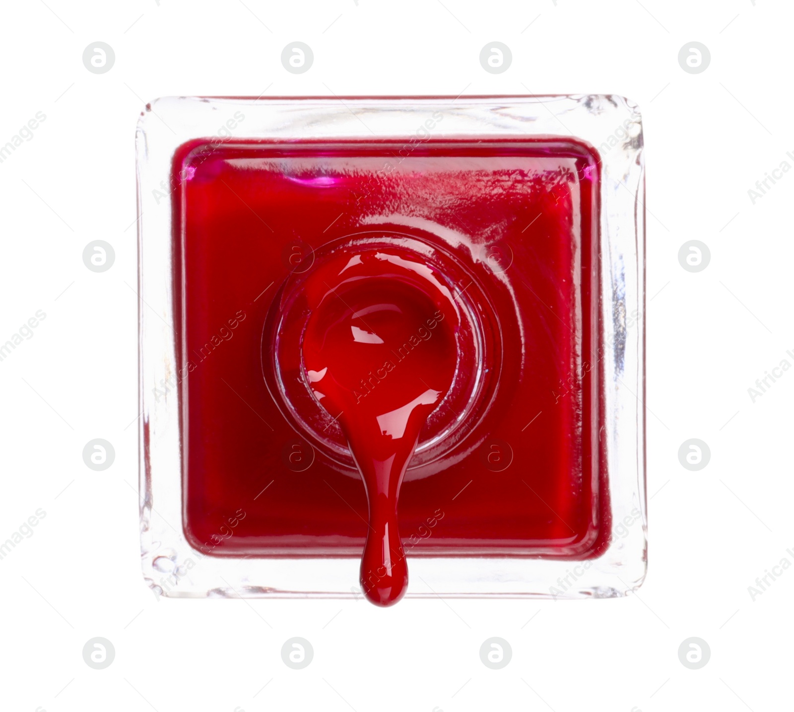 Photo of Red nail polish dripping from bottle isolated on white