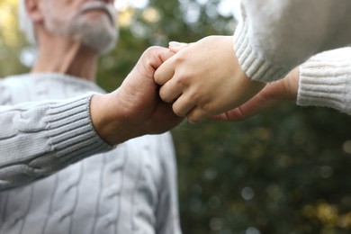 Photo of Trust and support. Woman with man joining hands outdoors, low angle view