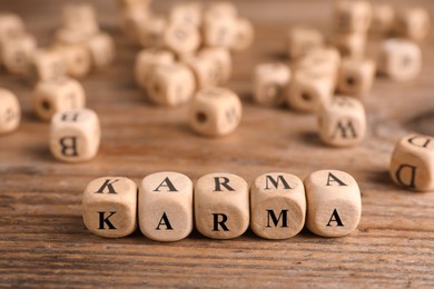 Word Karma made of cubes with letters on wooden table