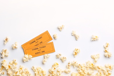 Popcorn and tickets on white background, top view. Cinema snack