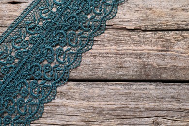 Photo of Beautiful lace on wooden table, top view. Space for text