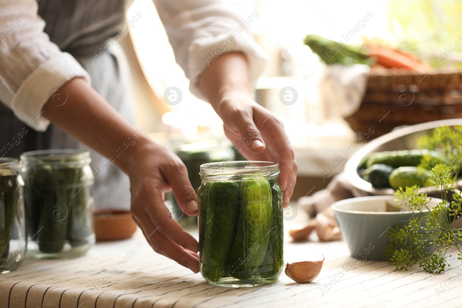 Photo of Woman canning cucumbers in kitchen, closeup view