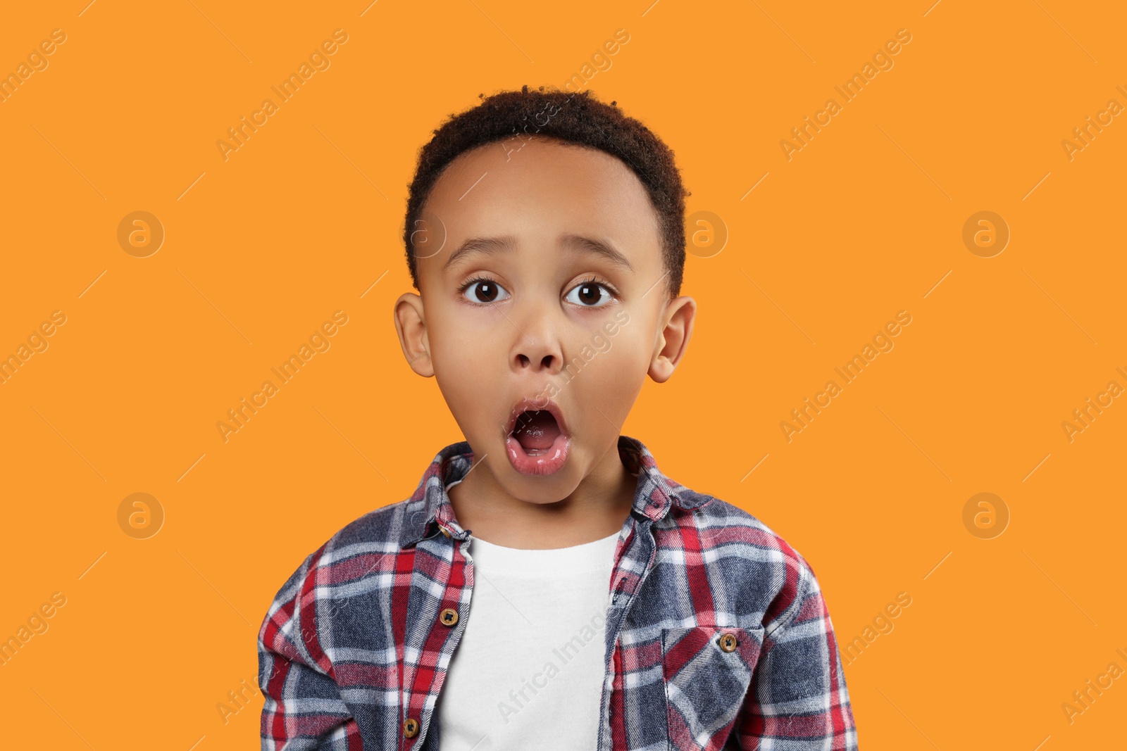 Photo of Portrait of emotional African-American boy on orange background