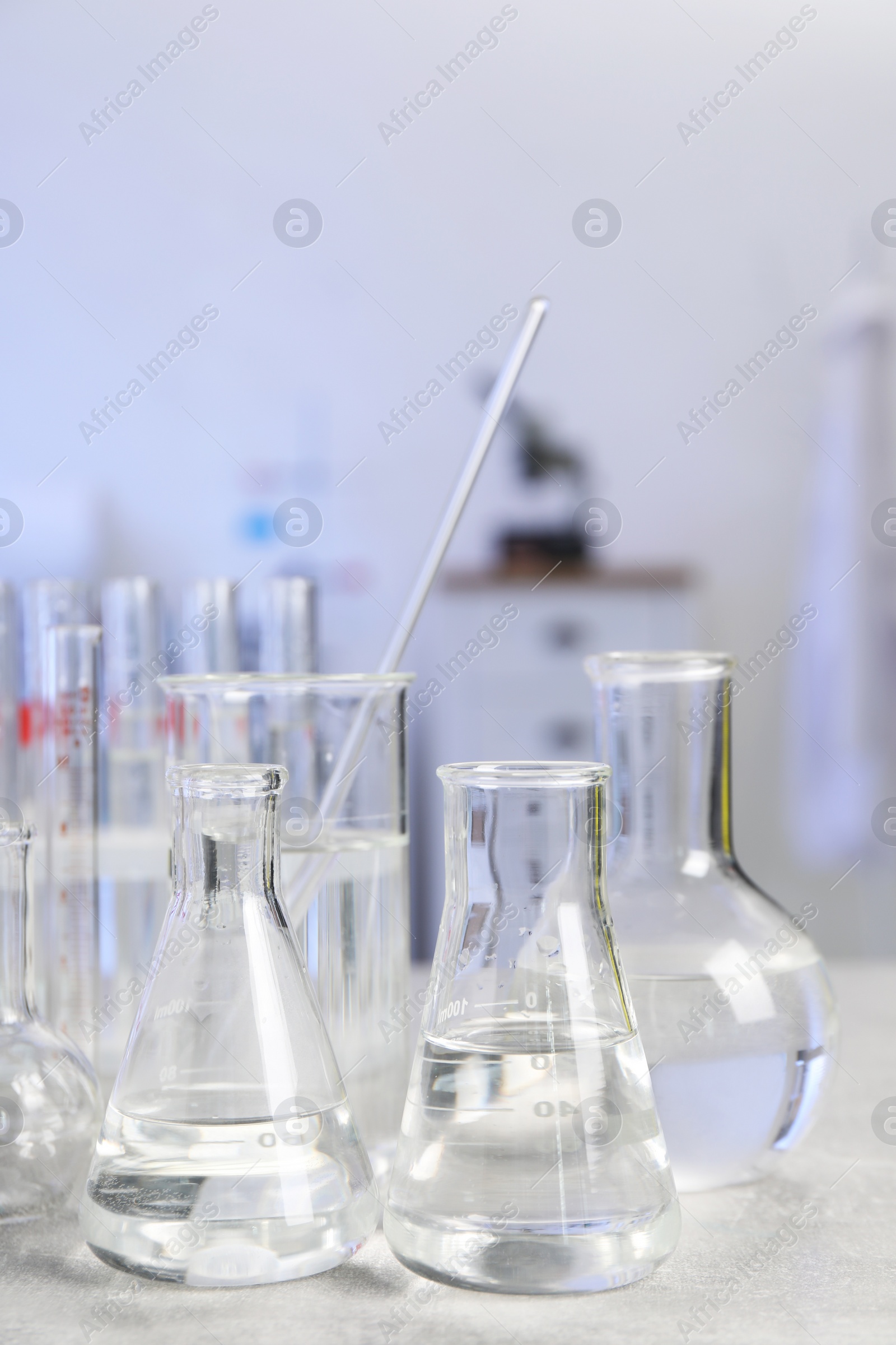 Photo of Laboratory analysis. Different glassware on light grey table indoors