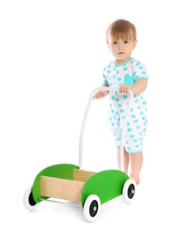 Cute baby playing with toy walker on white background