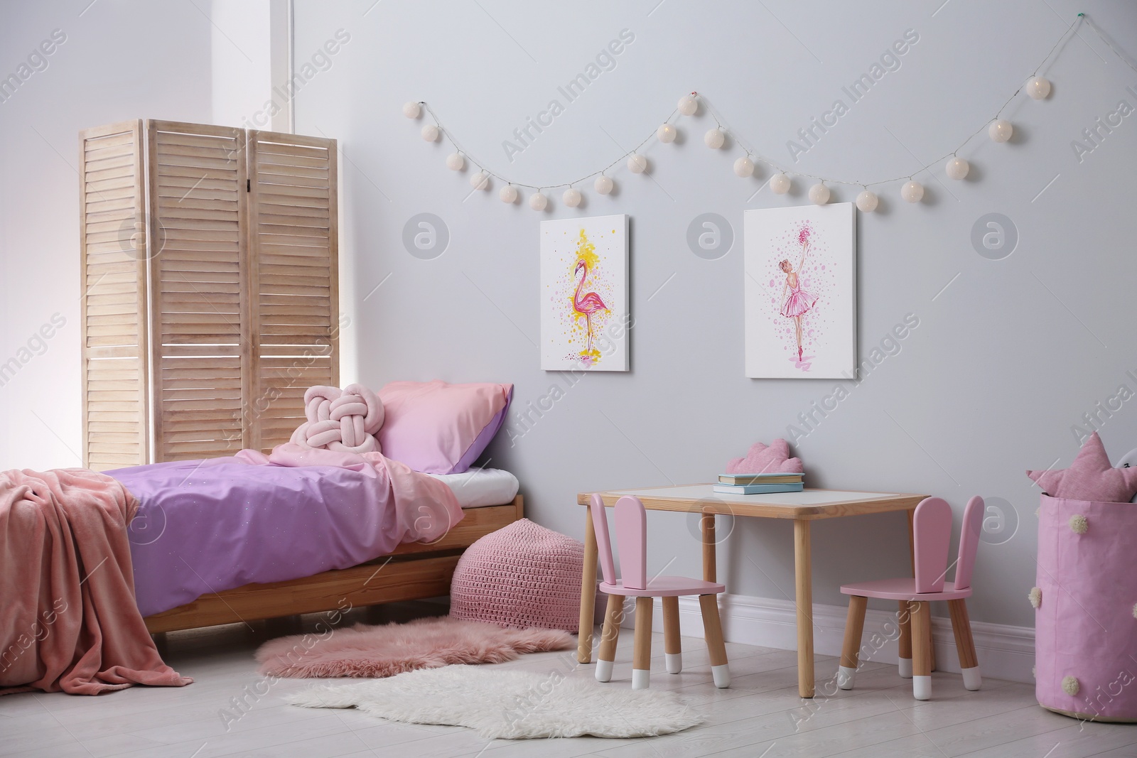 Photo of Comfortable bed with pink linens in children's room