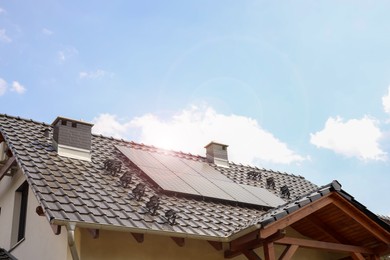 Photo of House with installed solar panels on roof. Alternative energy