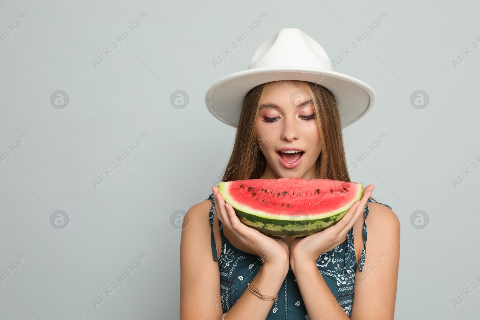 Photo of Beautiful girl with watermelon on grey background. Space for text