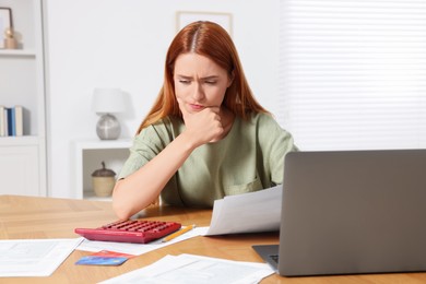 Woman calculating taxes at table in room
