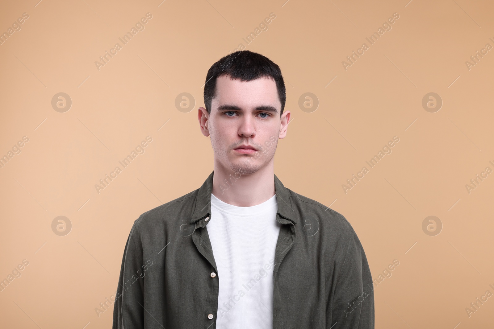 Photo of Portrait of sad man on beige background