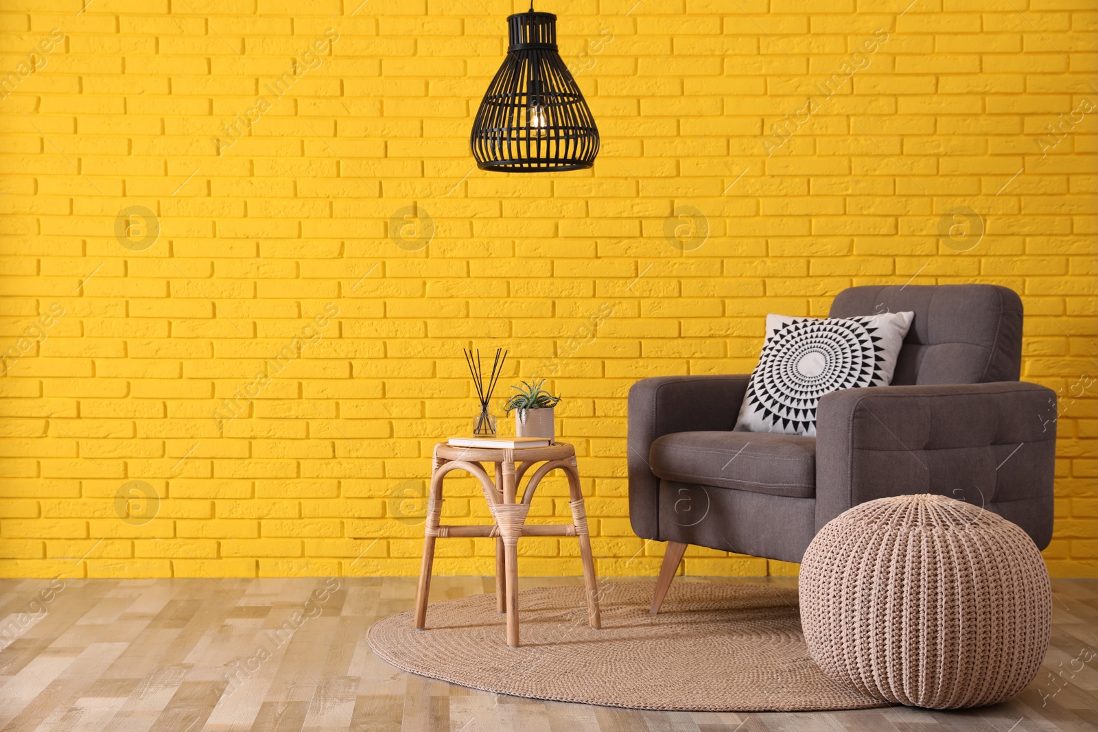 Photo of Stylish beige pouf, armchair and small table in room. Space for text